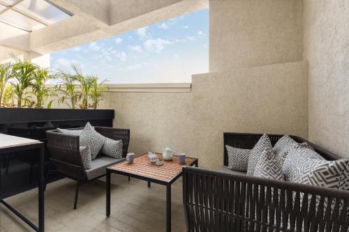 a patio with a table and chairs and a window at Fortune Walkway Mall, Haldwani - Member ITC Hotels' Group in Haldwāni