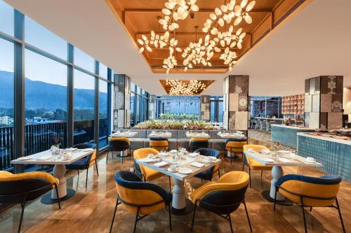 a restaurant with tables and chairs and windows at Fortune Walkway Mall, Haldwani - Member ITC Hotels' Group in Haldwāni