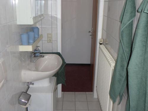 a bathroom with a sink and a green towel at Ferienwohnung Stadtblick in Bräunlingen