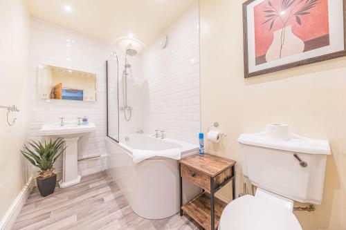 a white bathroom with a toilet and a sink at Waingarth Cottage Grizedale Forest & Satterthwaite in Ulverston