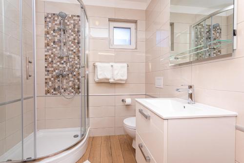 a bathroom with a shower and a sink and a toilet at Apartments Crnekovic Tomislava 8 in Baška