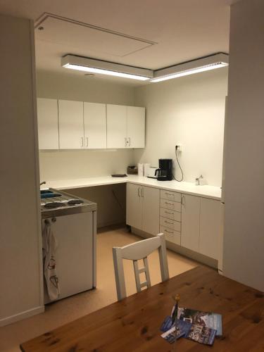 a kitchen with white cabinets and a wooden table at Apartments in Henån in Henån
