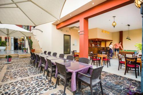 a dining room with tables and chairs and people in the background at Grand Hotel Madaba in Madaba