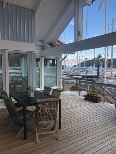 a wooden deck with a table and chairs and a marina at Apartments in Henån in Henån