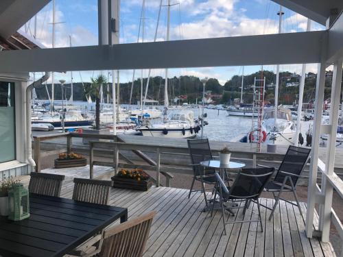 a deck with tables and chairs and a marina at Apartments in Henån in Henån