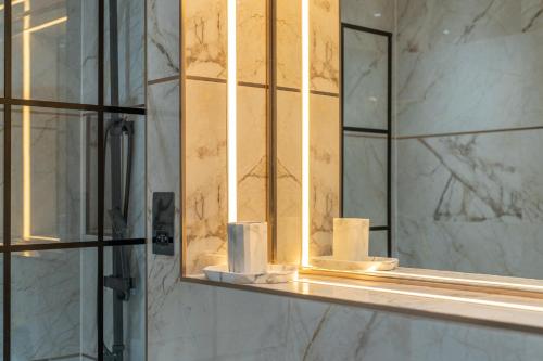 einem Badezimmerspiegel mit Rollen Toilettenpapier auf einem Regal in der Unterkunft Brand New London Luxury House - Sleeps 8 in London