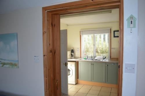 a kitchen with a sink and a washing machine at C15 Seamore, Riviere Towans in Hayle