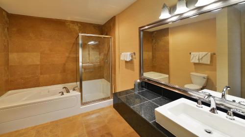 y baño con bañera, lavabo y aseo. en Prestige Inn Golden en Golden