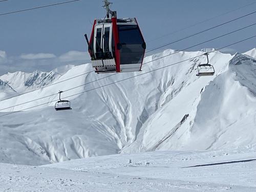 two ski lifts flying over a snow covered mountain at Delux apartment for 6 guest, new gudauri in Gudauri