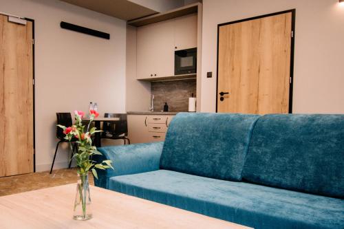 a blue couch in a living room with a table at Ruben Hotel Zielona Góra in Zielona Góra