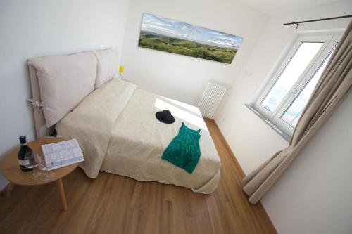 Schlafzimmer mit einem Bett, einem Tisch und einem Fenster in der Unterkunft Ciabot Apartments in Treiso
