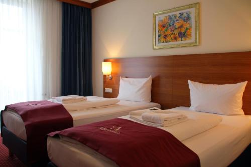 um quarto de hotel com duas camas e uma janela em Abasto Hotel Eichenau em Eichenau