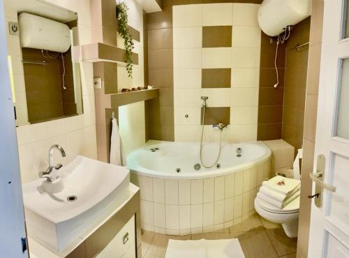a bathroom with a tub and a toilet and a sink at Apartament Na Skarpie in Nowy Targ