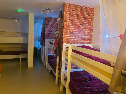 a room with three bunk beds and a brick wall at Hostel OT in Split