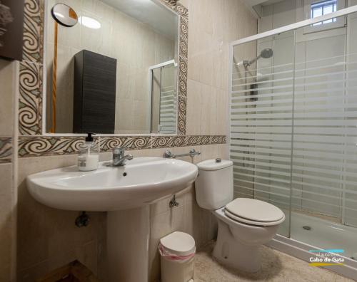 a bathroom with a sink and a toilet and a mirror at Calilla de San José in San José