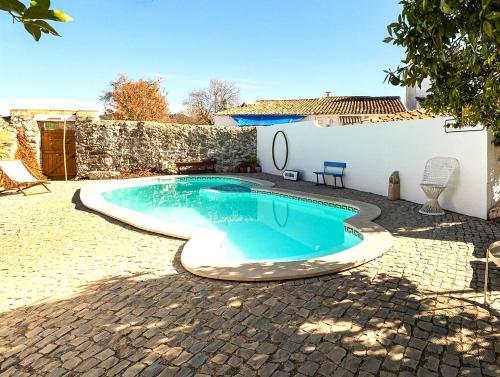 una piscina en un patio al lado de un edificio en Casa do Torreão, en Salir