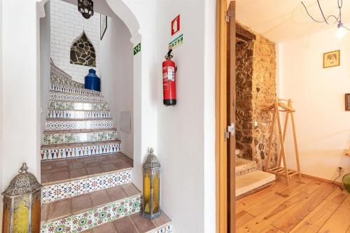 una escalera con un extintor de incendios en la pared en Casa do Torreão, en Salir