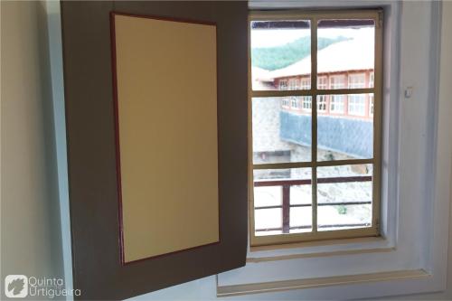 a window with a view of a building at Quinta da Urtigueira in Felgueiras