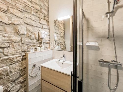 baño con lavabo y pared de piedra en El Forn de Freixenet con servicios de un hotel, en Lleida