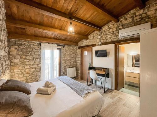 a bedroom with a large bed in a stone wall at El Forn de Freixenet con servicios de un hotel in Lleida