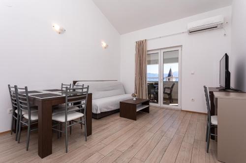 a living room with a bed and a table and chairs at Apartments Crnekovic Tomislava 8 in Baška
