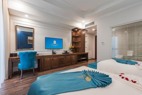 a hotel room with two beds and a desk at Grand Fleuve Boutique in Ha Long