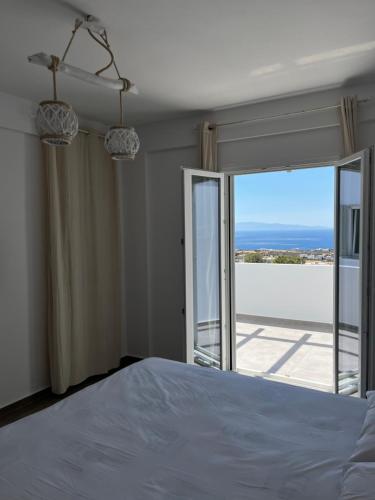 a bedroom with a bed and a view of the ocean at White Villas Paros in Kampos Paros