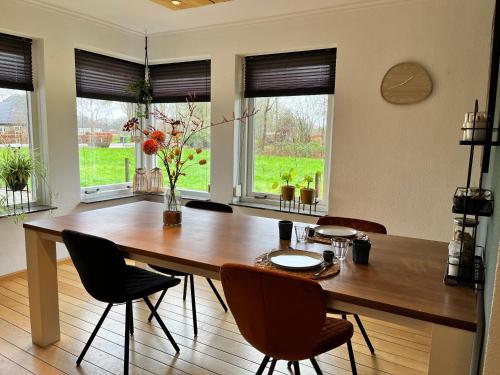 uma sala de jantar com uma mesa de madeira e cadeiras em Bed and Breakfast De Beekhoek em Glane