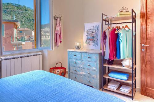 a bedroom with a blue dresser and a blue bed at GINEVRA House in Levanto