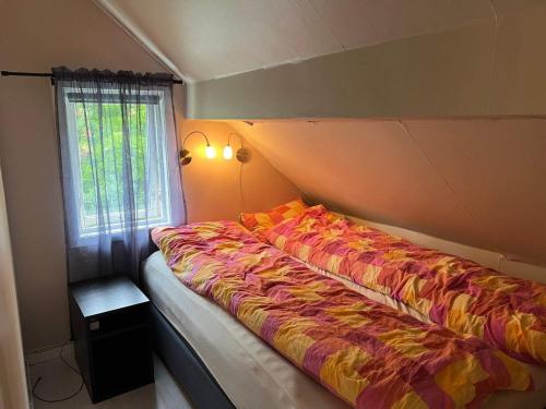 a bed in a room with a window at Holiday home Brandasund II in Rolvsnes