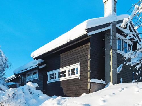 a log cabin with snow on the roof at 10 person holiday home in Svingvoll-By Traum in Svingvoll