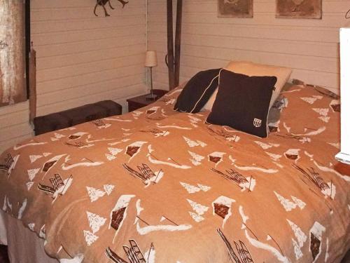 a bed with a comforter on it in a bedroom at 10 person holiday home in Svingvoll-By Traum in Svingvoll