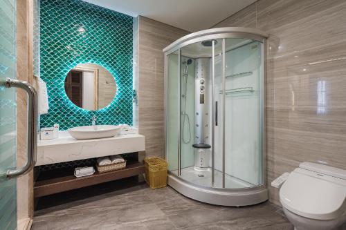 a bathroom with a shower and a toilet and a sink at Grand Fleuve Boutique in Ha Long
