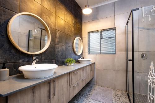 a bathroom with two sinks and a mirror at Rozelee Rest 1 in Nelspruit