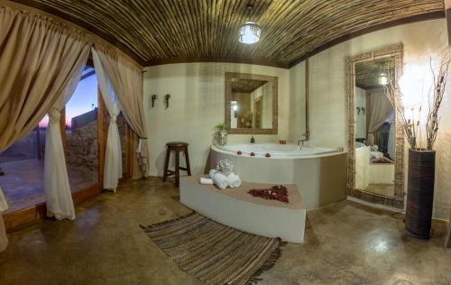 La grande salle de bains est pourvue d'une baignoire et d'un lavabo. dans l'établissement Emoya Basotho Lodge, à Bloemfontein