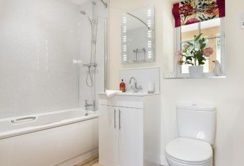 biała łazienka z toaletą, wanną i umywalką w obiekcie The Garden Apartment a luxurious Rural Retreat w mieście Wellington