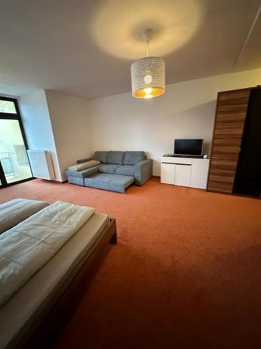 a living room with a bed and a couch at Pension COLUMBIA inkl. Frühstück im Zentraum in Bad Gleichenberg