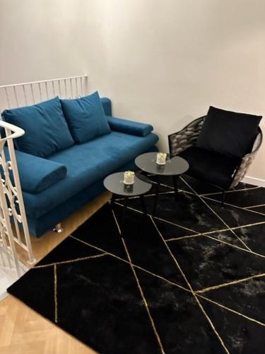 a living room with a blue couch and two tables at Pension COLUMBIA inkl. Frühstück im Zentraum in Bad Gleichenberg