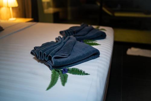 three blue towels sitting on top of a bed at The Cosy Maenam Beach Resort in Mae Nam