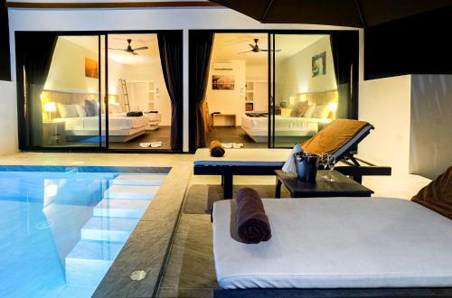 a living room with a pool and a bedroom at The Cosy Maenam Beach Resort in Mae Nam