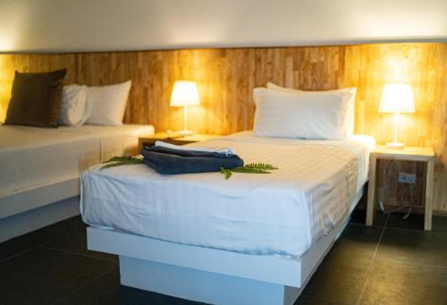 a bedroom with two beds with white sheets and two lamps at The Cosy Maenam Beach Resort in Mae Nam