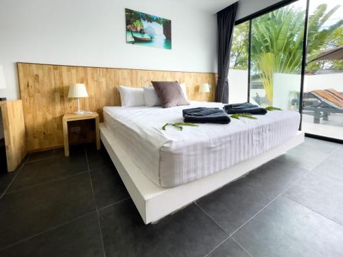 a bedroom with a large bed with white sheets at The Cosy Maenam Beach Resort in Mae Nam