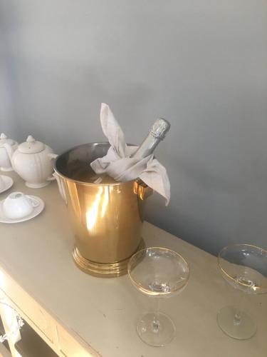 a gold bucket on a counter with two wine glasses at Palacete Encanto Maior in Campo Maior