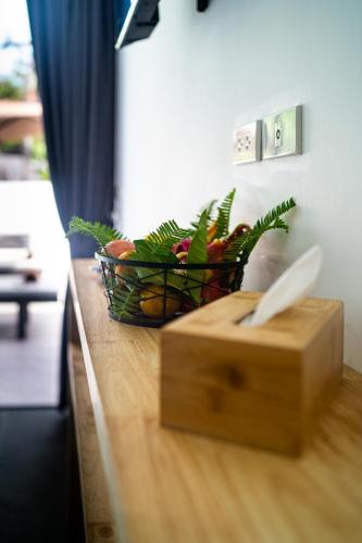 a basket of fruit on top of a counter with a knife at The Cosy Maenam Beach Resort in Mae Nam