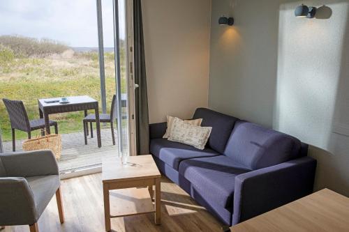 a living room with a blue couch and a table at TUI BLUE Sylt in Rantum