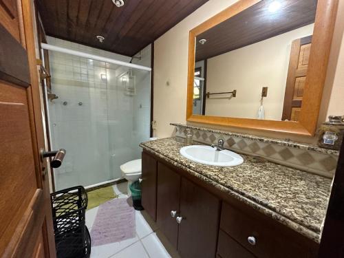 a bathroom with a sink and a shower and a mirror at Casa da Ogiva in Cabo Frio