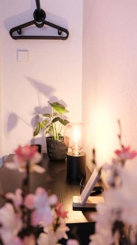 a table with a lamp and flowers on it at Stadtoase Design Wohnung in der Altstadt von Koblenz in Koblenz