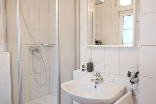 a white bathroom with a sink and a shower at Stadtoase Design Wohnung in der Altstadt von Koblenz in Koblenz