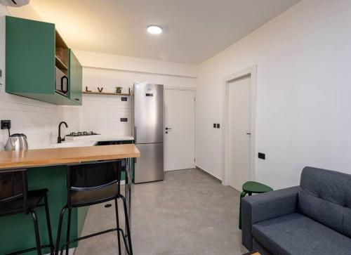 eine Küche mit einem Kühlschrank und einem Sofa in einem Zimmer in der Unterkunft Boutique Central old town Apartment in Be’er Scheva