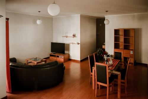 ein Wohnzimmer mit einem schwarzen Sofa und einem Tisch in der Unterkunft Recanto da Madeira. in Ribeira Brava